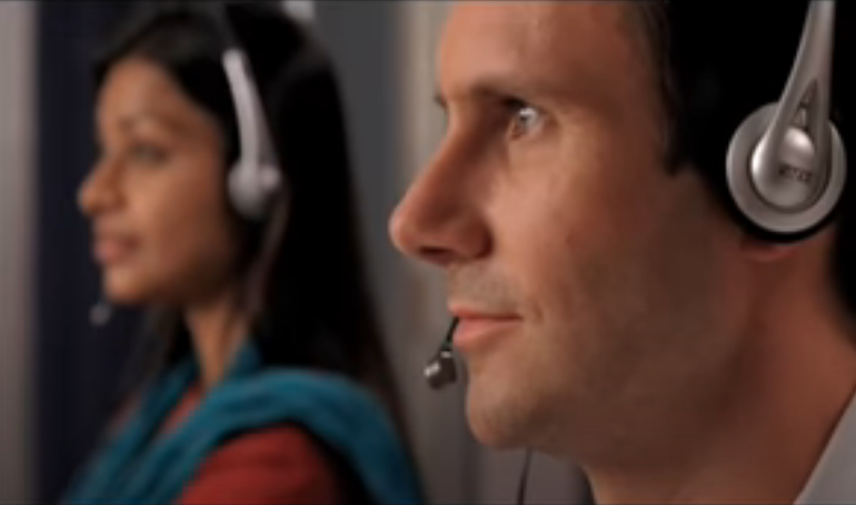 A man and woman take calls at a call center