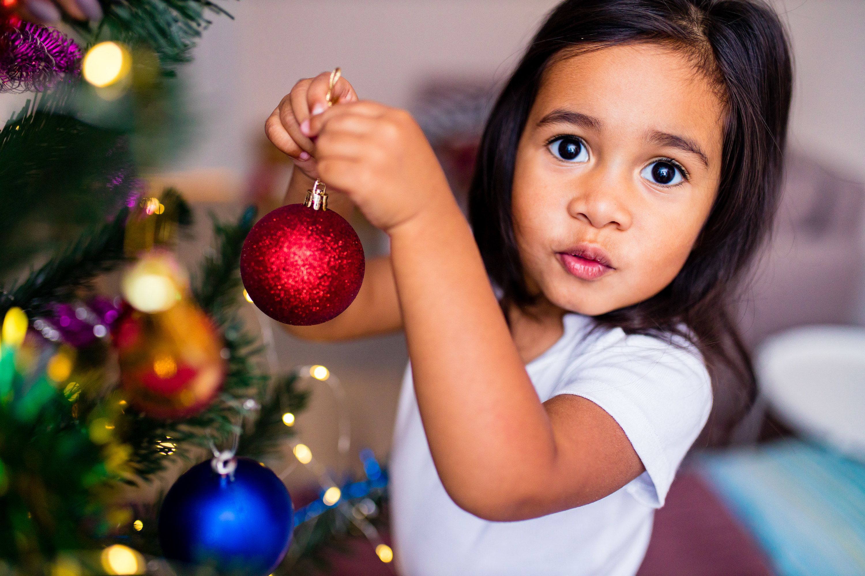child putting up christmas ornaments