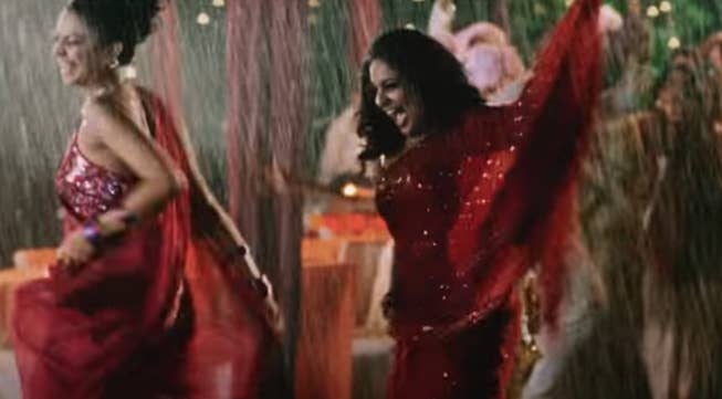 Women in saris dance in the rain