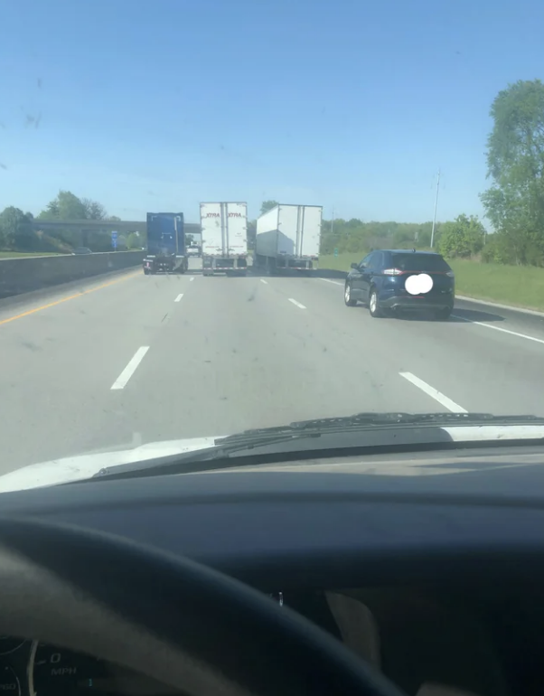 three semi trucks next to each other across three lanes