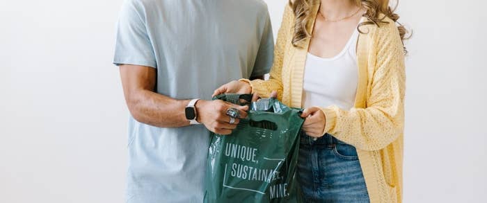Two people holding a shopping bag.