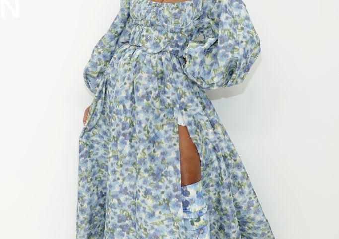 Keke poses for photographers in a off-the-shoulder floral print dress