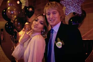 Jlo and Owen Wilson in Marry Me posing for prom photos