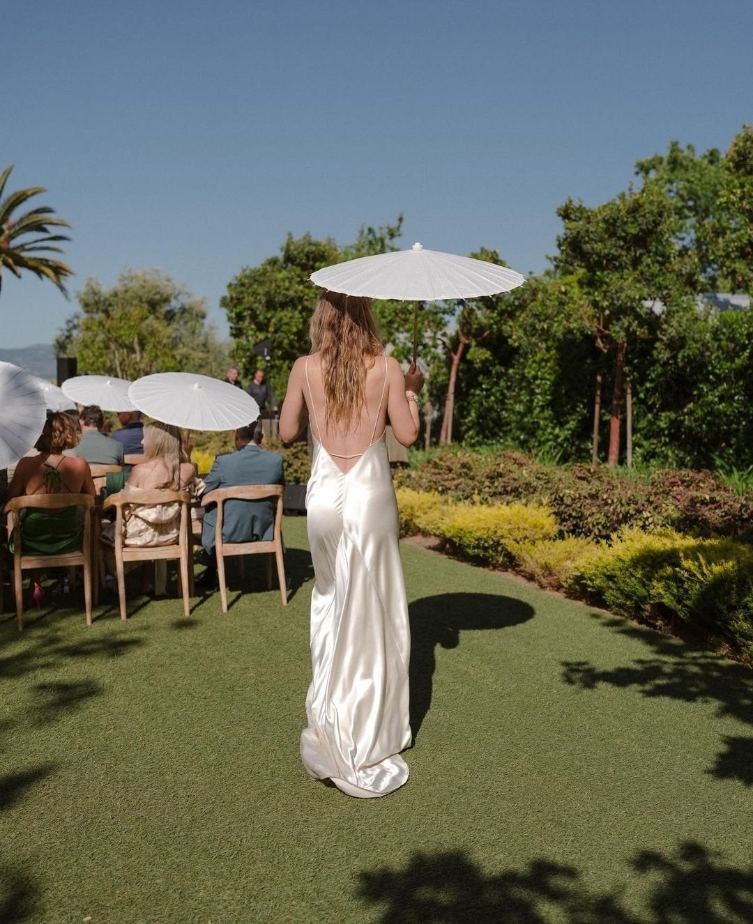 olivia in the wedding dress holding a sun umbrella