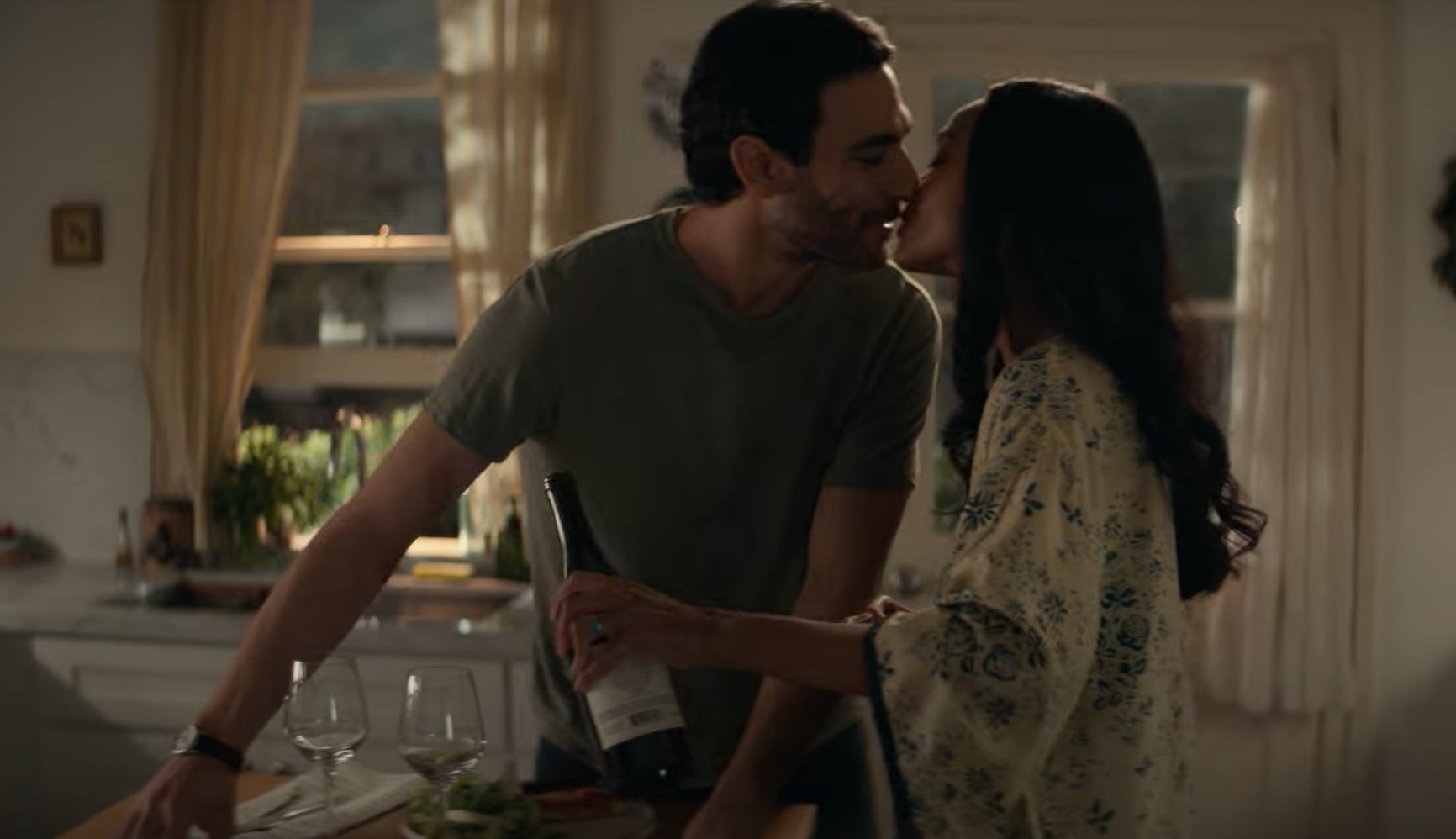 在一个场景从Netflix系列& # x27;从划痕# x27;利诺和艾米吻在厨房里厨师和她握着一瓶葡萄酒
