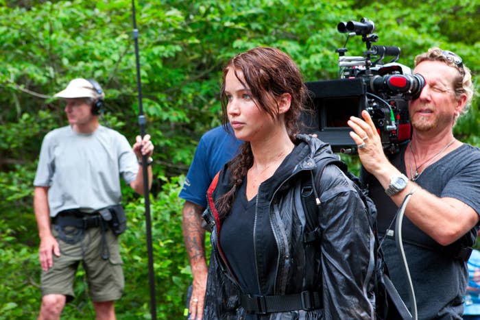 Jennifer Lawrence filming a scene for The Hunger Games with a camera person behind her