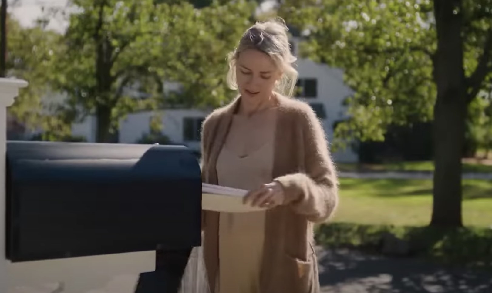 In a scene from &#x27;The Watcher&#x27; Naomi Watts looks down at letters as she pulls them from a mailbox