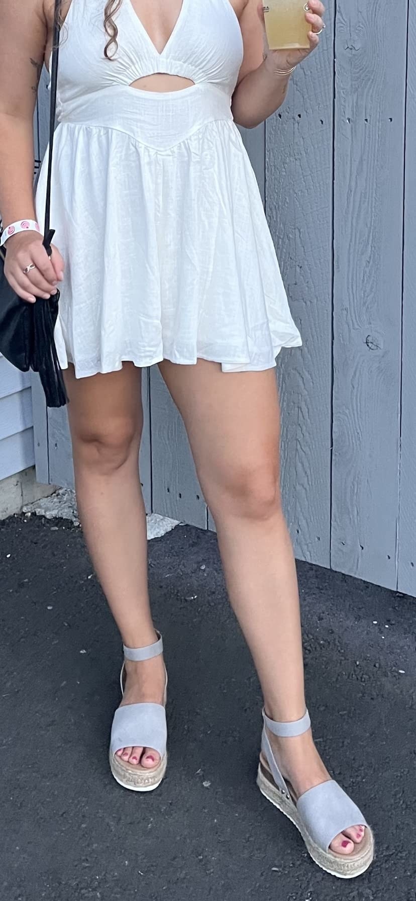 Reviewer in grey sandals with white dress