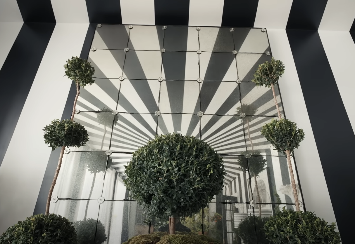 wall of mirrors with topiaries in the outdoor dining room