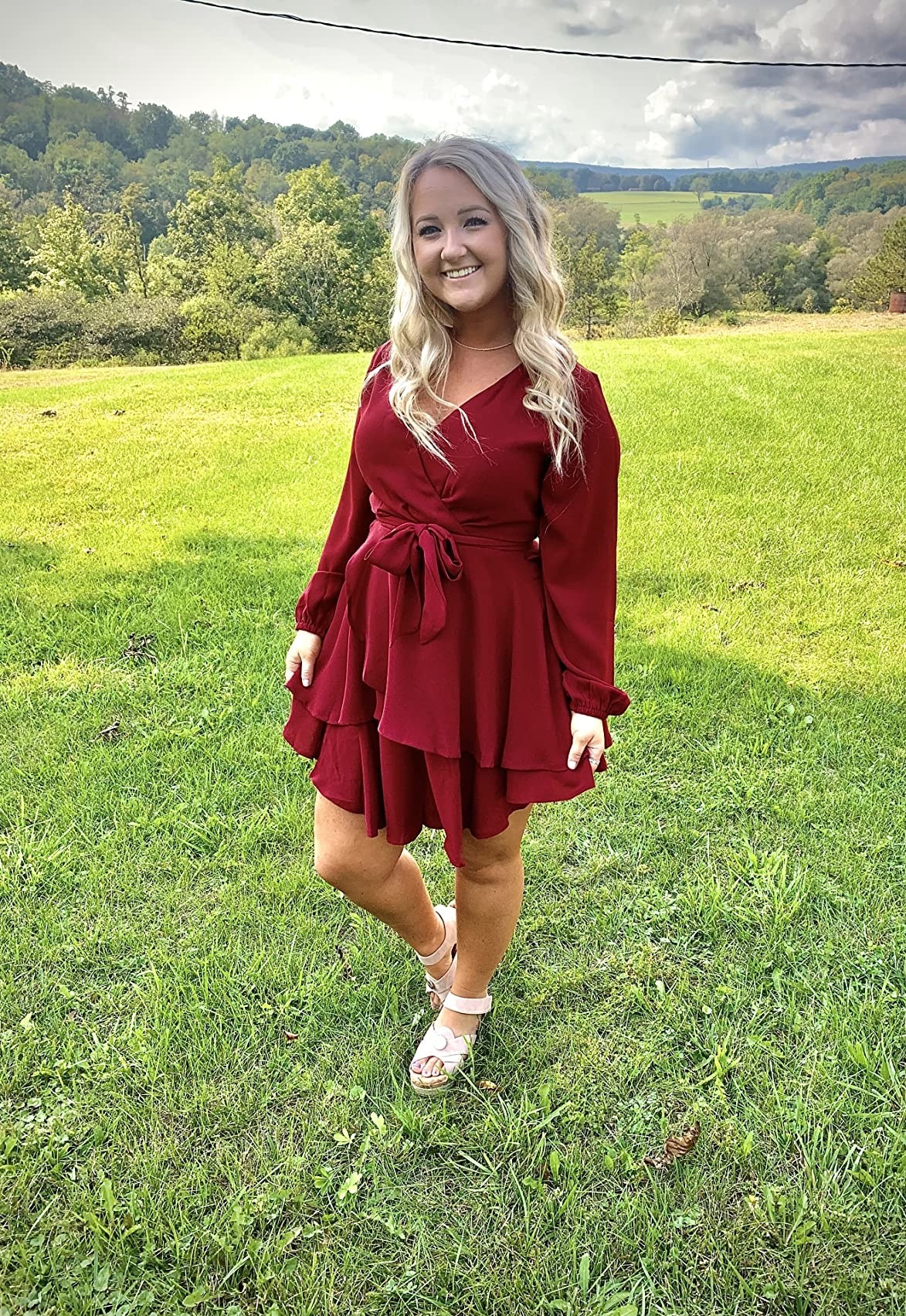 Reviewer standing in grass in red dress