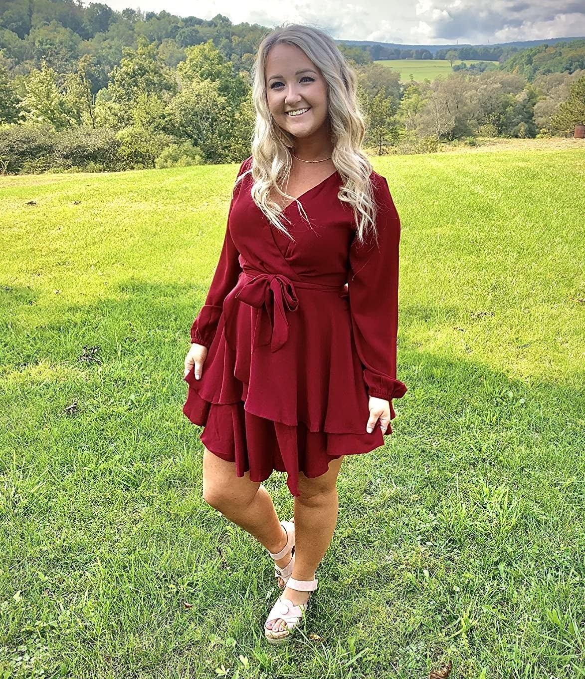 Reviewer standing in grass in red dress