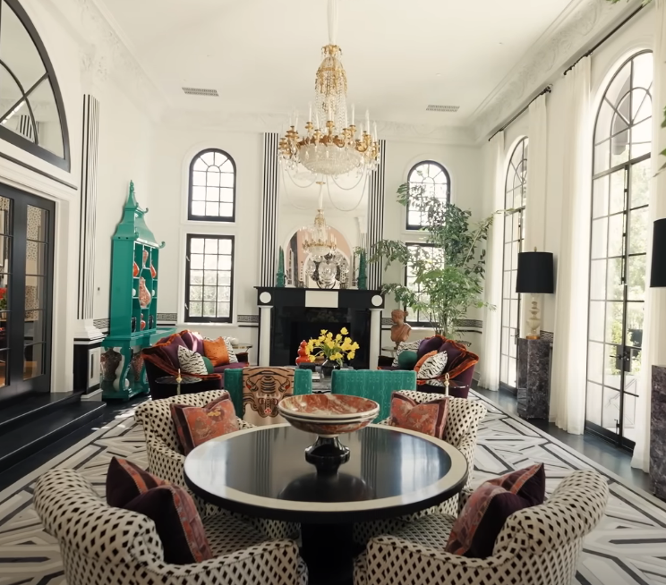 large living room with jewel tone furniture, tall ceilings, and ornate designs throughout