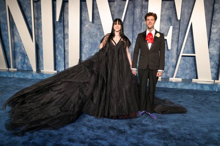 Billie and Jesse hold hands at a vanity fair event as photographers take their pictures