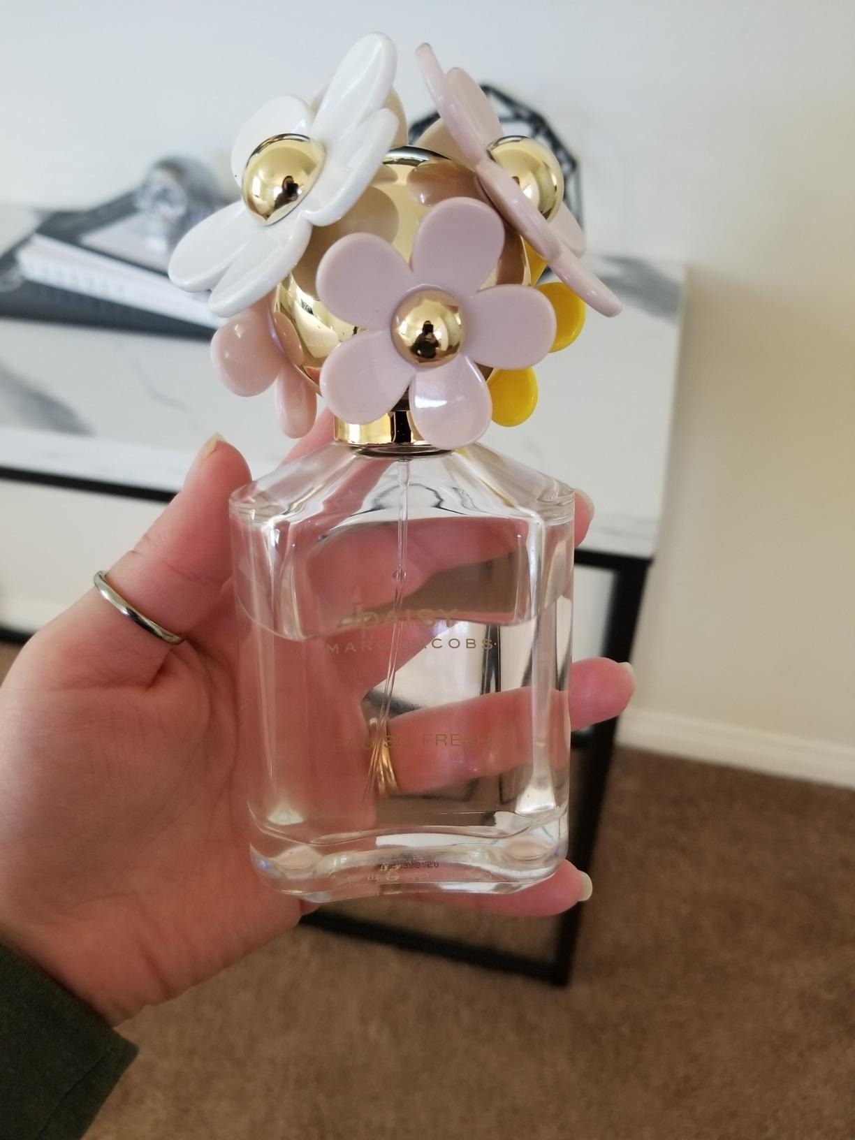 reviewer holding daisy-shaped bottle of the Marc Jacobs perfume