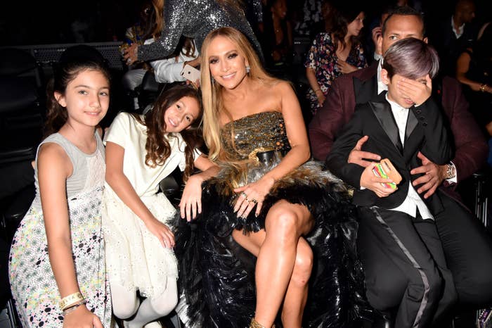 JLo and Alex Rodriguez with her twins and one of his daughters sitting at a formal event