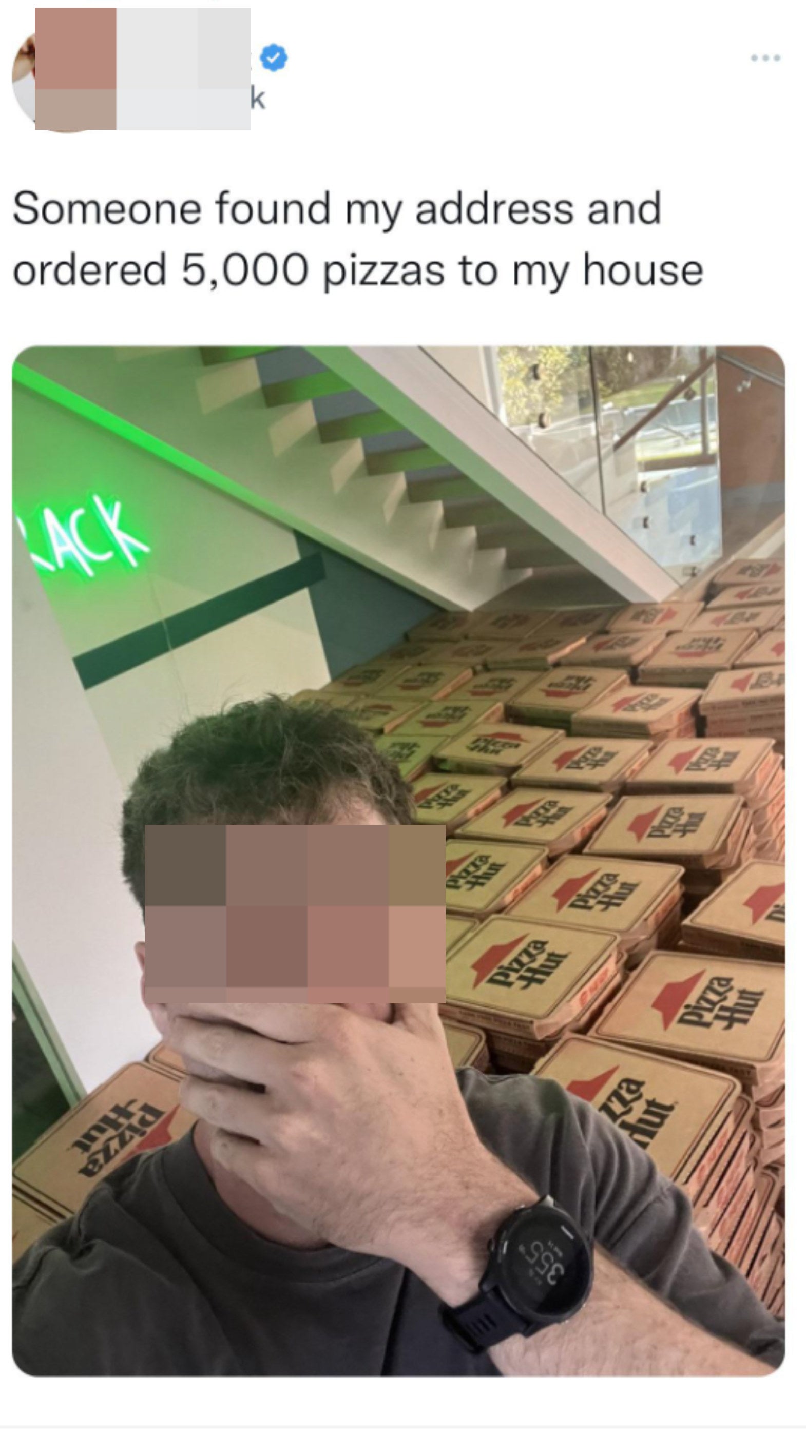 man standing in front of 5000 pizza boxes saying they were accidentally delivered to his house