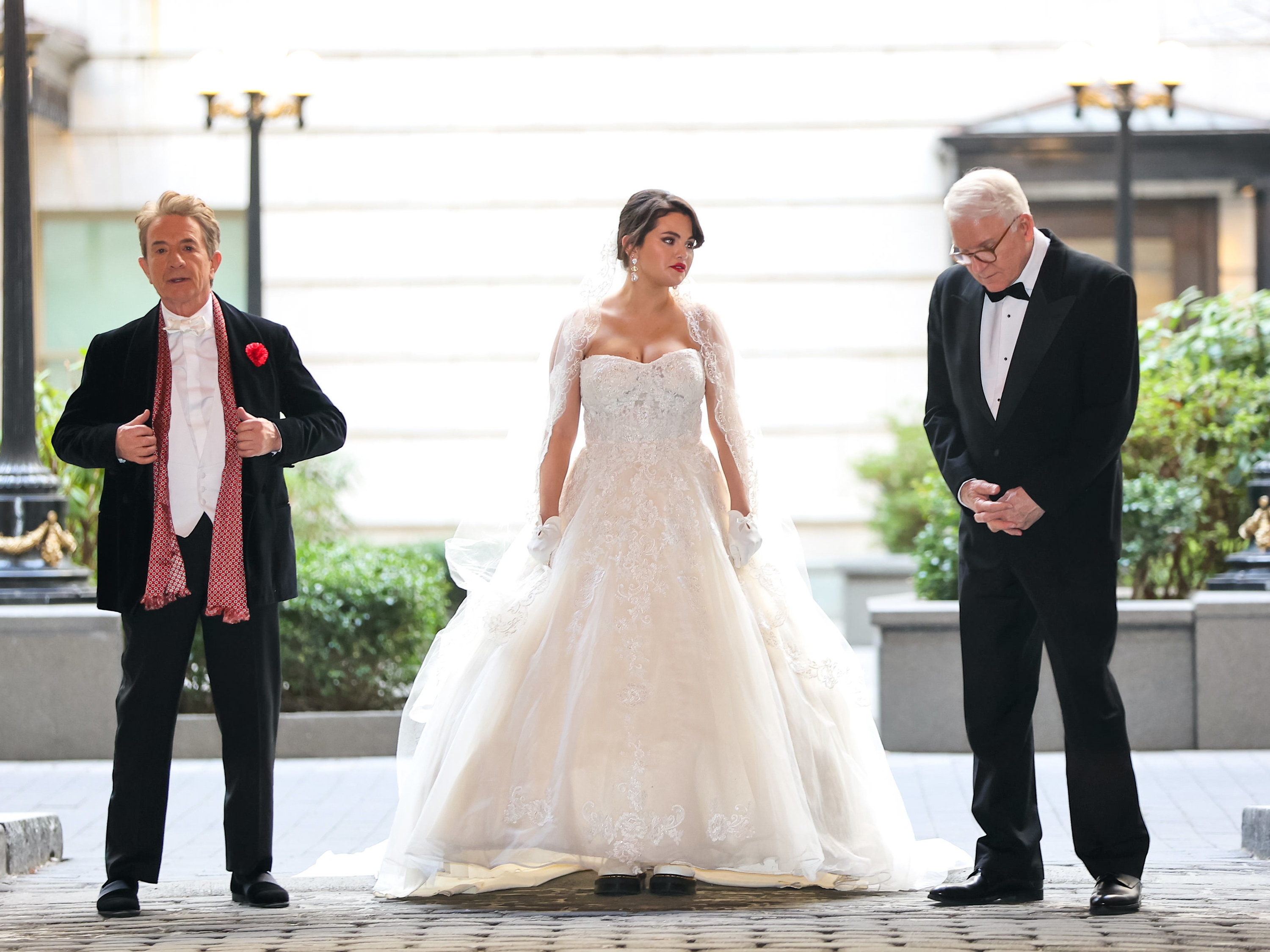 martin short, selena gomez, and steve martin on the set of only murders in the building. In the shot Selena is wearing a wedding gown