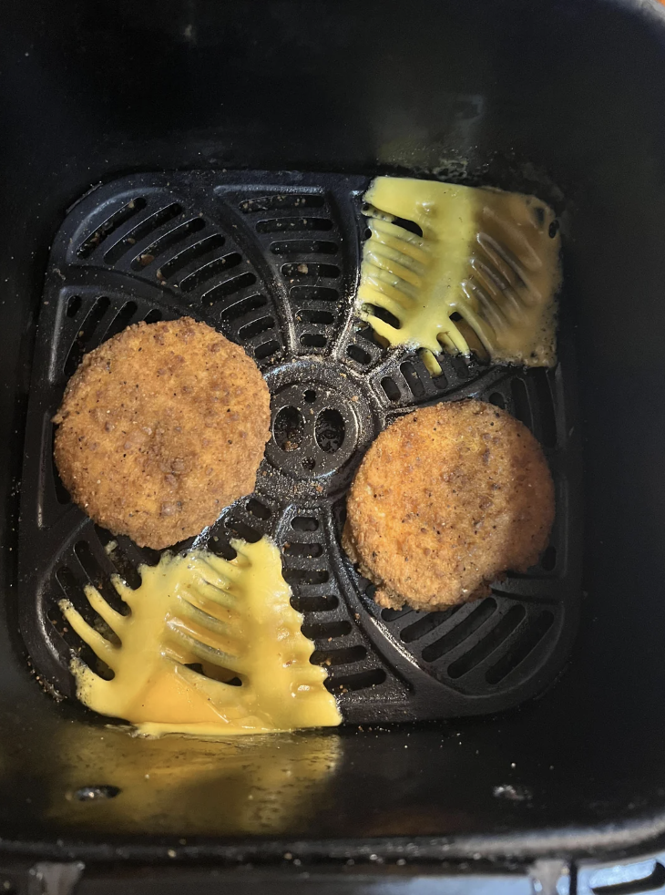 Cheese on a grill next to chicken patties