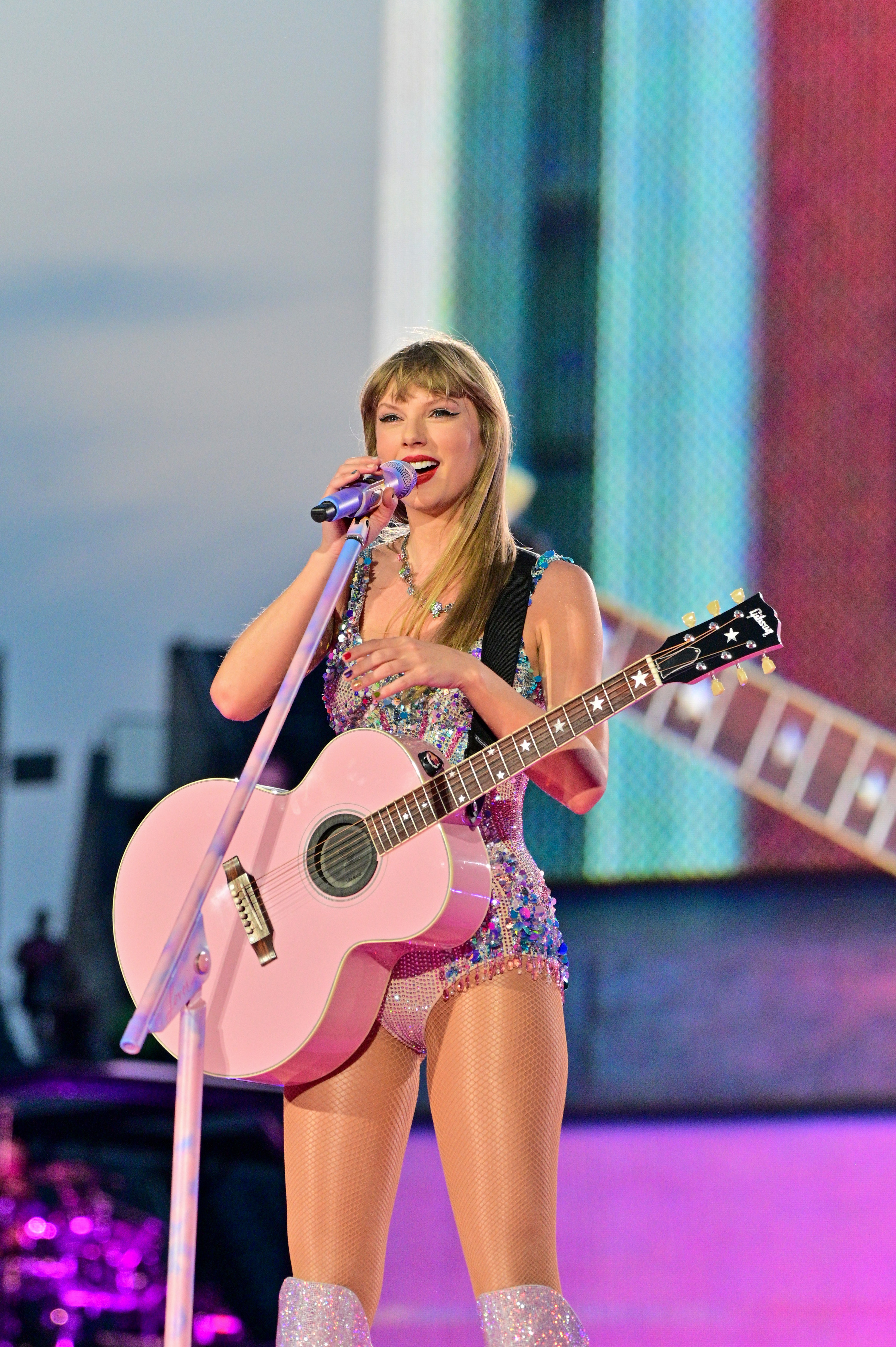 Taylor performing onstage with a guitar