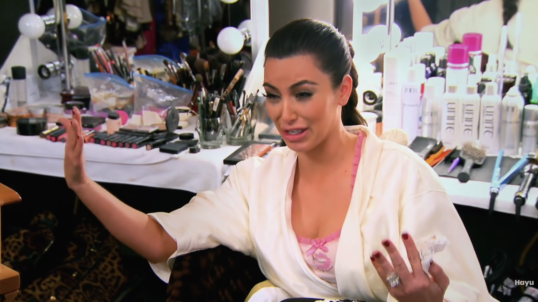 Kim crying in front of a vanity mirror