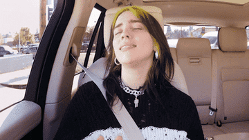 Billie eilish singing with eyes closed during a carpool karaoke session
