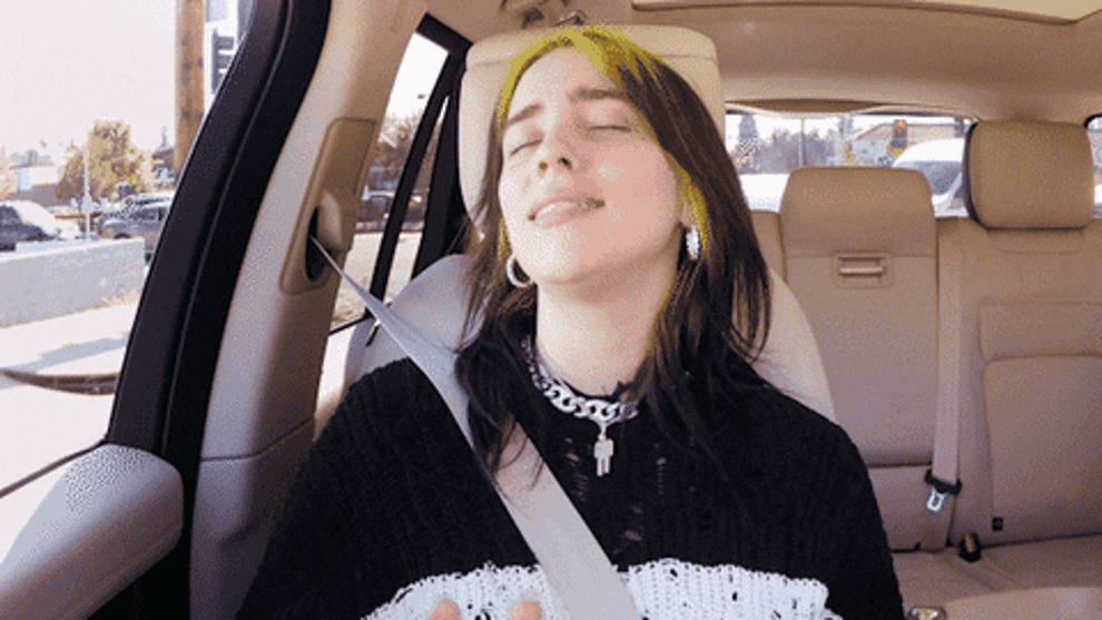 Billie eilish singing with eyes closed during a carpool karaoke session