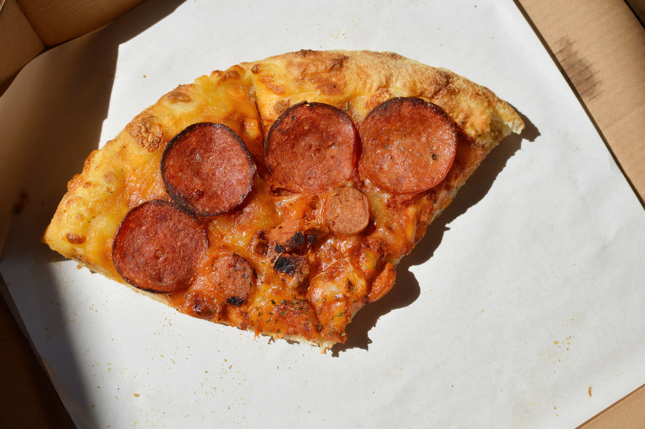 Two pepperoni pizza slices inside a pizza box.