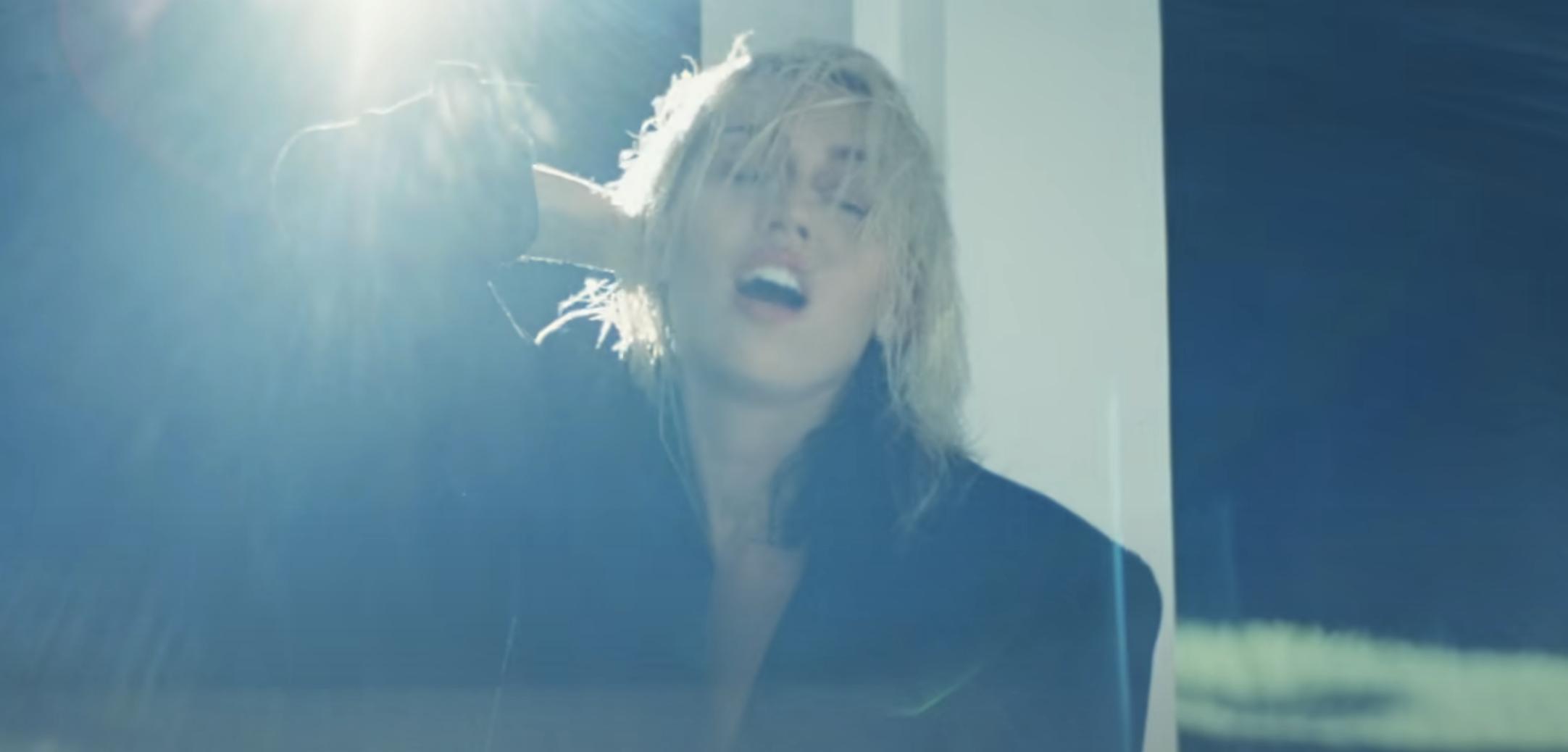 A closeup of Miley Cyrus singing in the music video for Flowers