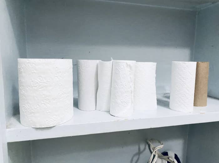 Instead of using one roll of toilet paper until it&#x27;s gone, there are several partially used rolls stacked next to each other