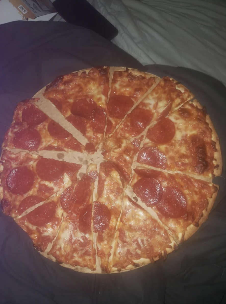 The pizza has been sliced seemingly at random, with each of the slices having uneven sides and sizes