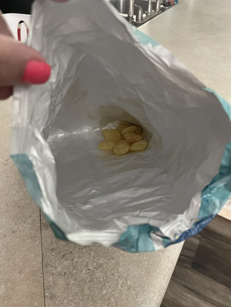 A bag of Chex Mix is empty except for six pieces of Chex at the bottom of the bag