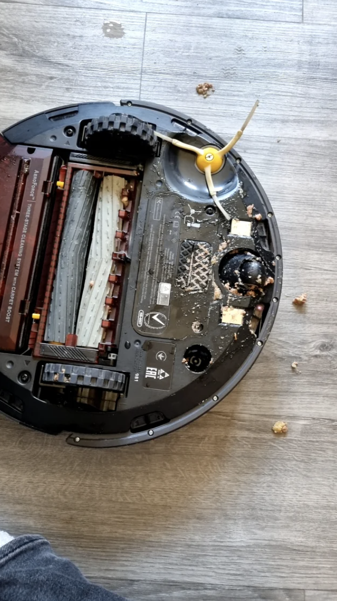 The underside of the Roomba is covered with gross-looking wet cat food