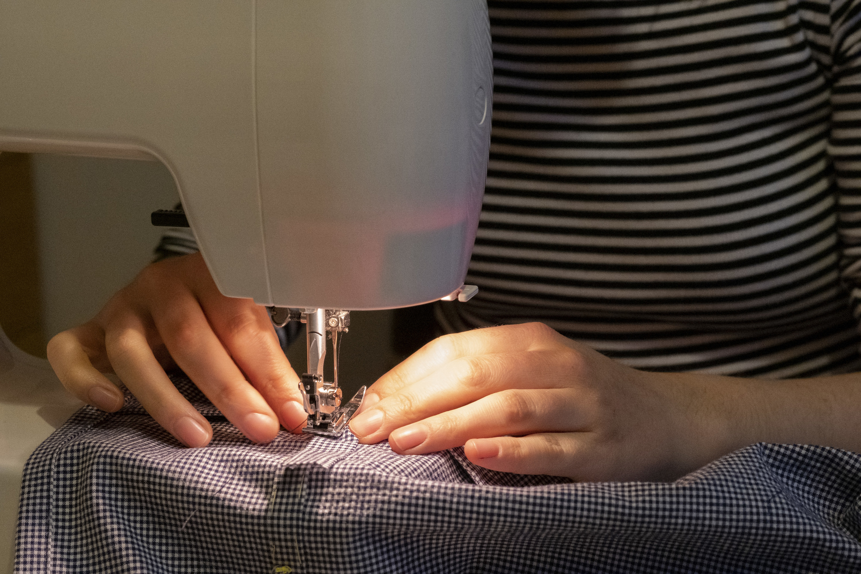 A woman sews a dress at home in March 2021