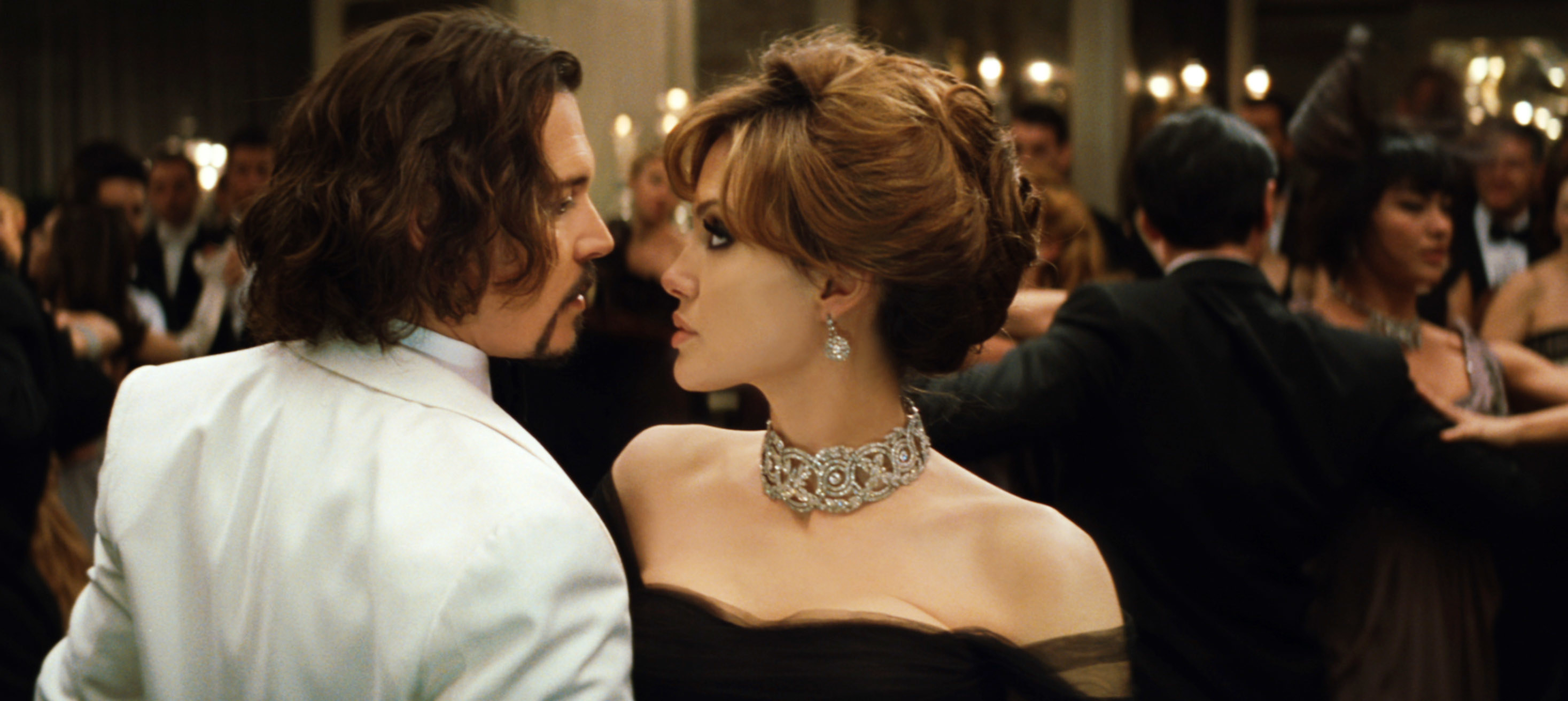 Johnny Depp and Angelina Jolie dance in a crowded ballroom in The Tourist
