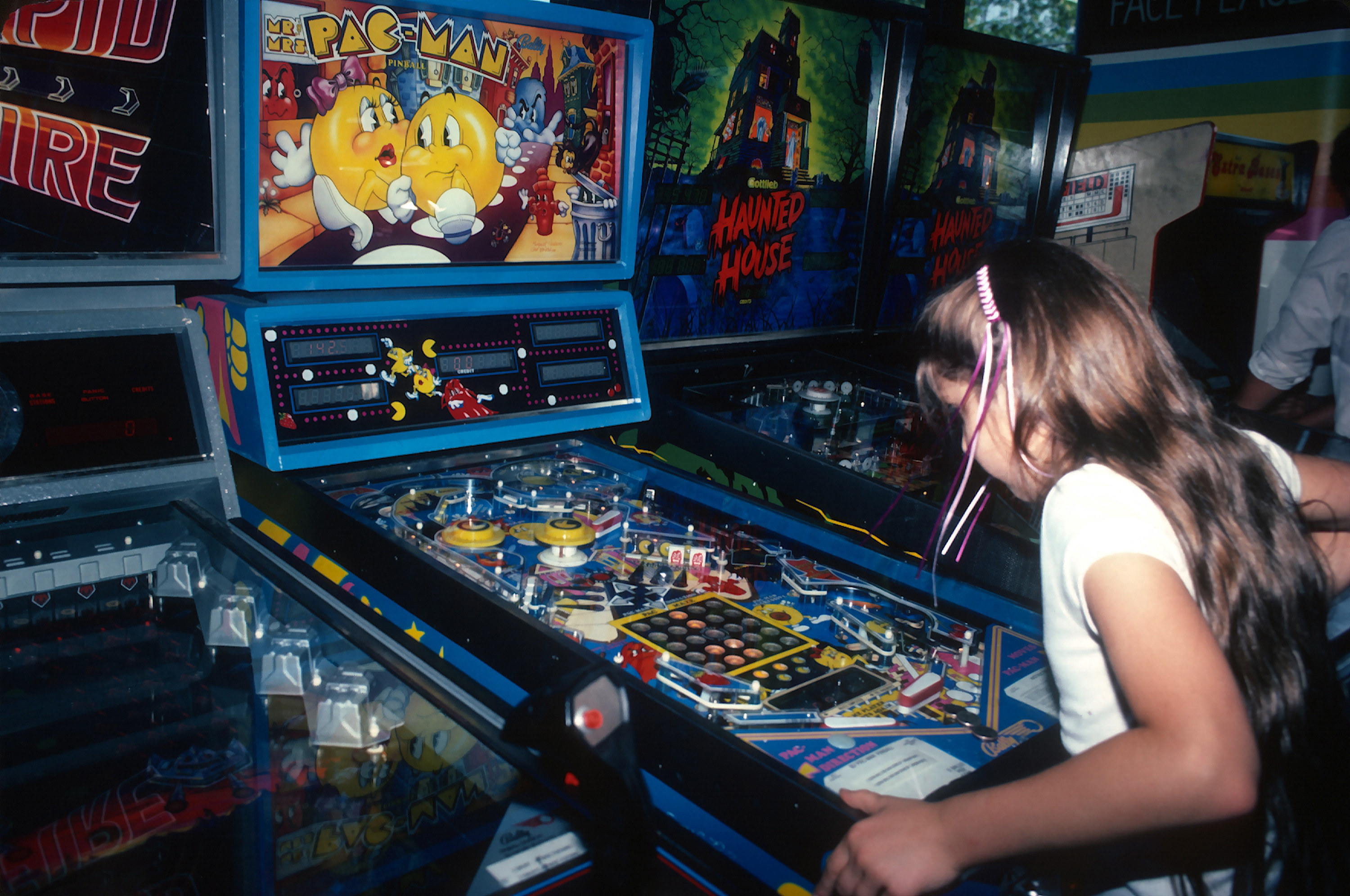 A young girl plays Pac-Man at an arcade in Times Square circa 1982