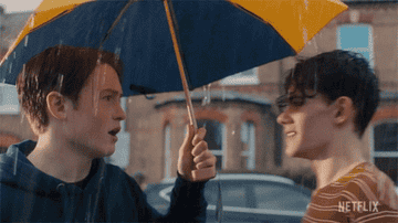 Toy boys under an umbrella with one saying, &quot;Hi&quot;