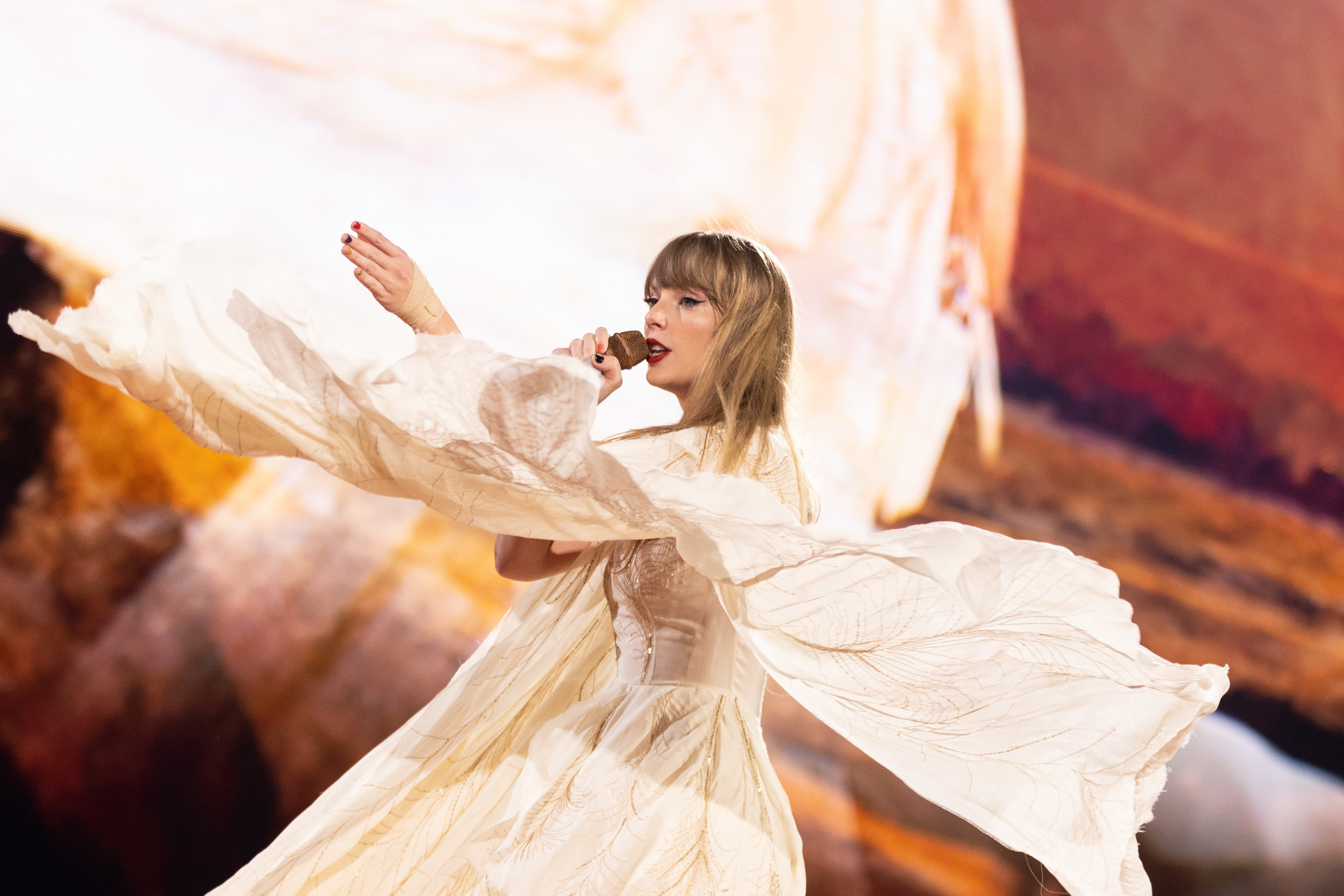 Taylor Swift wearing a white boho style dress