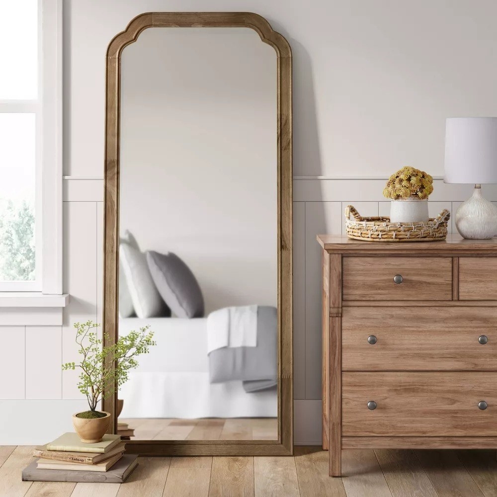 The full-length mirror against a wall in a bedroom