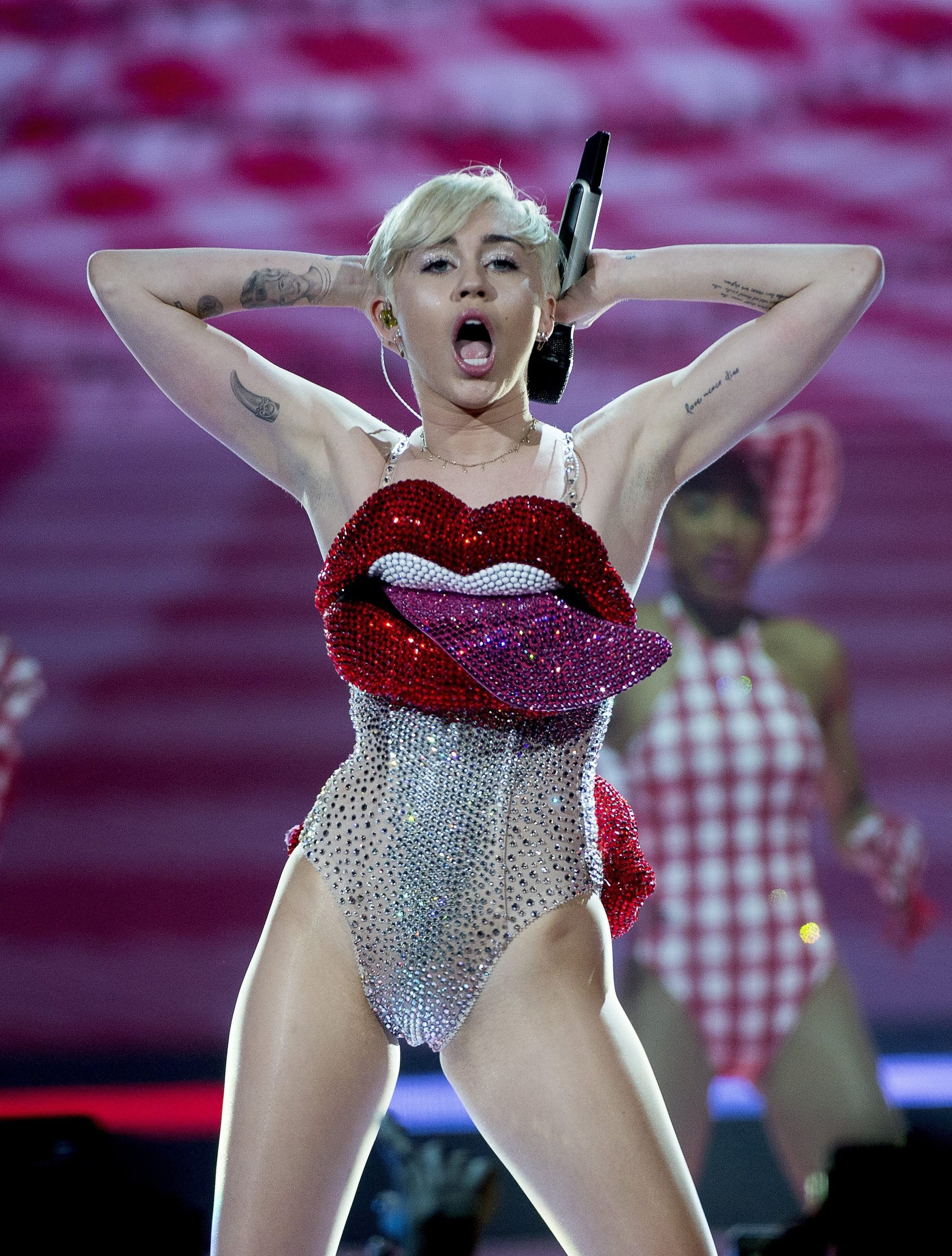 Miley performing onstage in a sparkly bodysuit