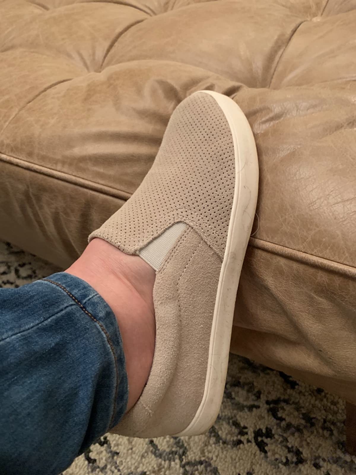 Reviewer wearing beige slip-on sneakers