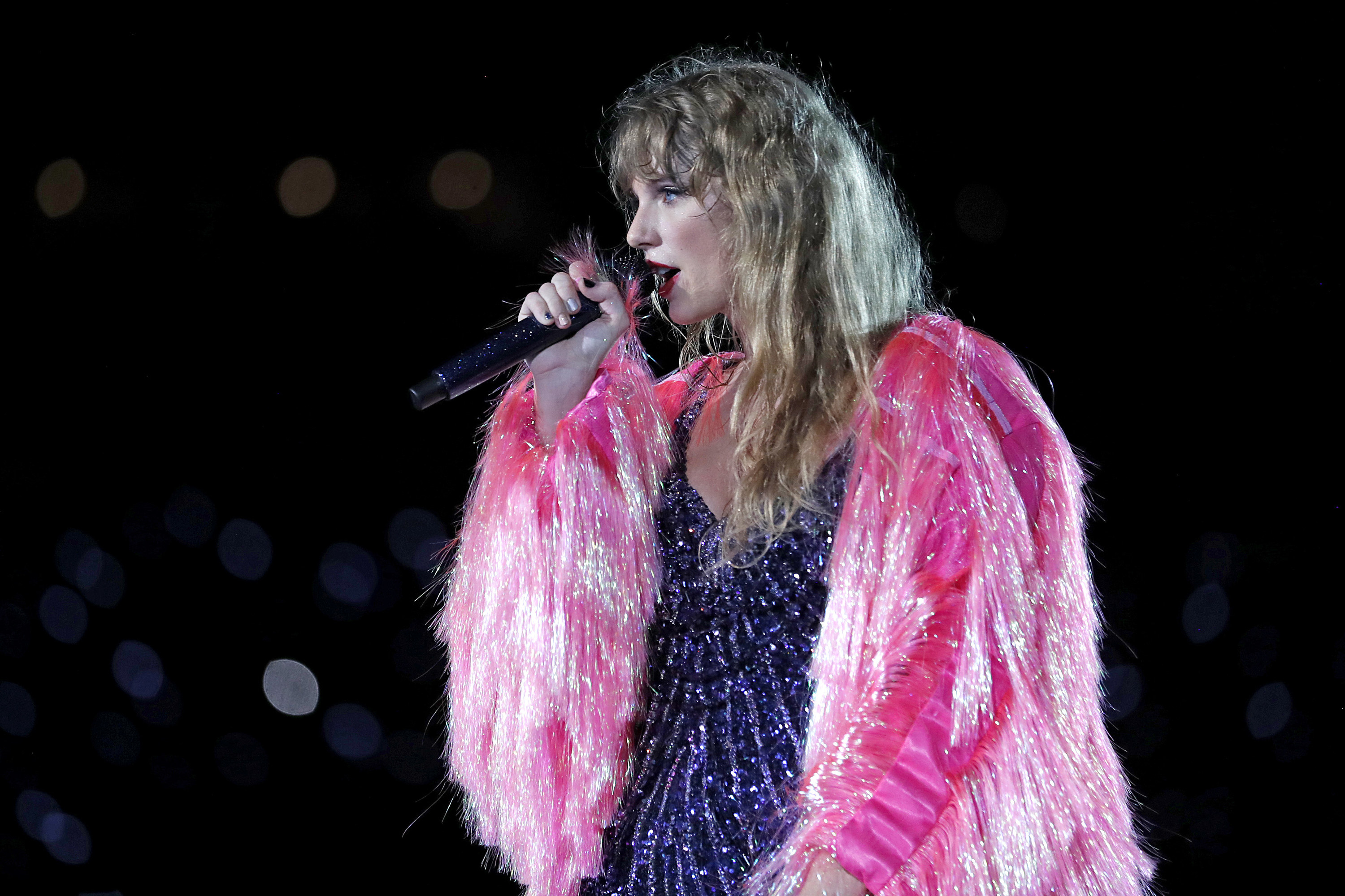 Taylor Swift wearing a pink frilly jacket