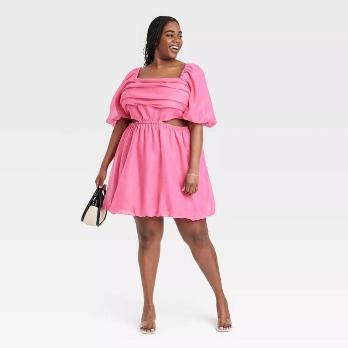 A model in the pink dress which falls above the knee