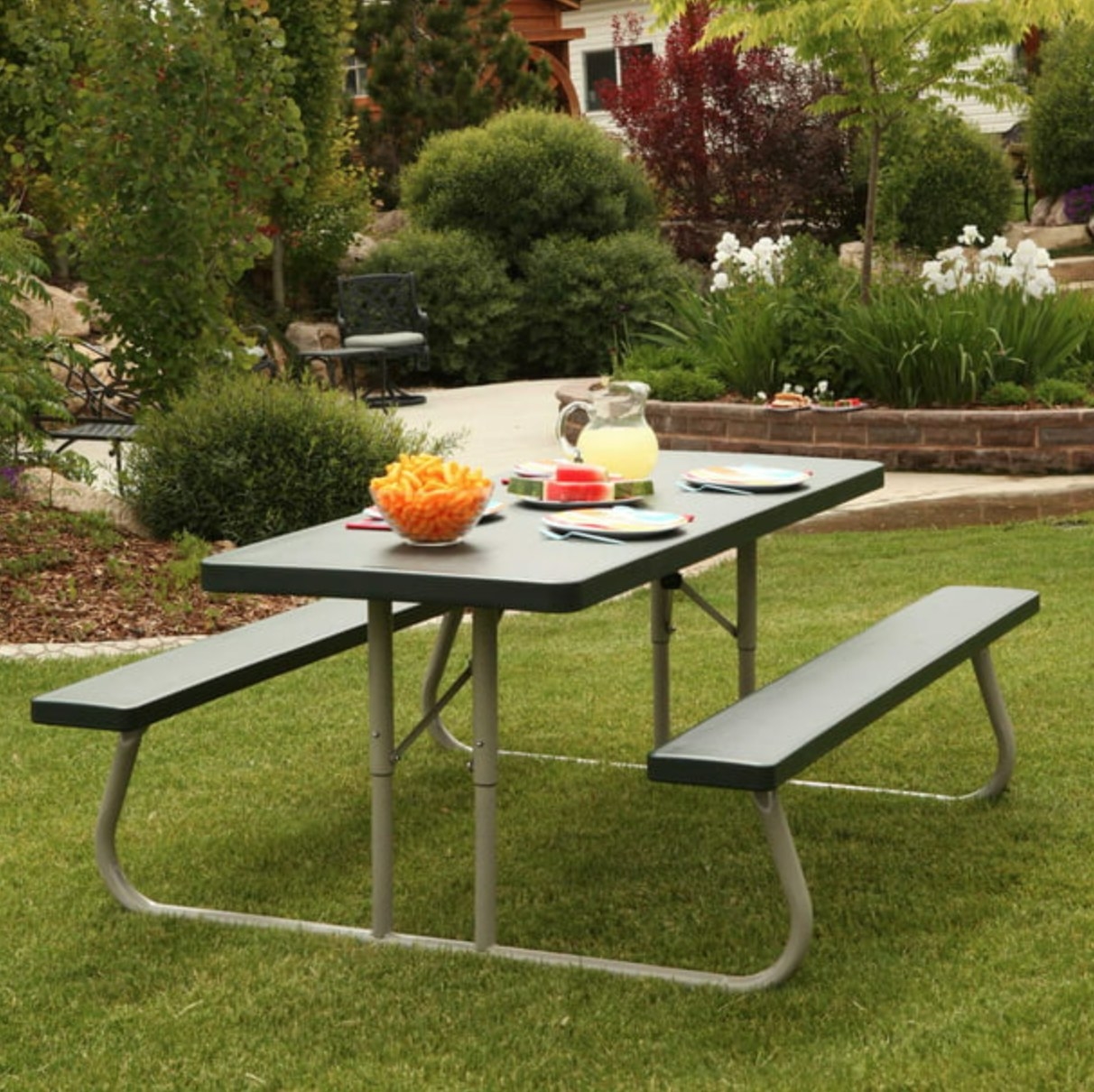 the green picnic table with a metal frame in a decorated outdoor space