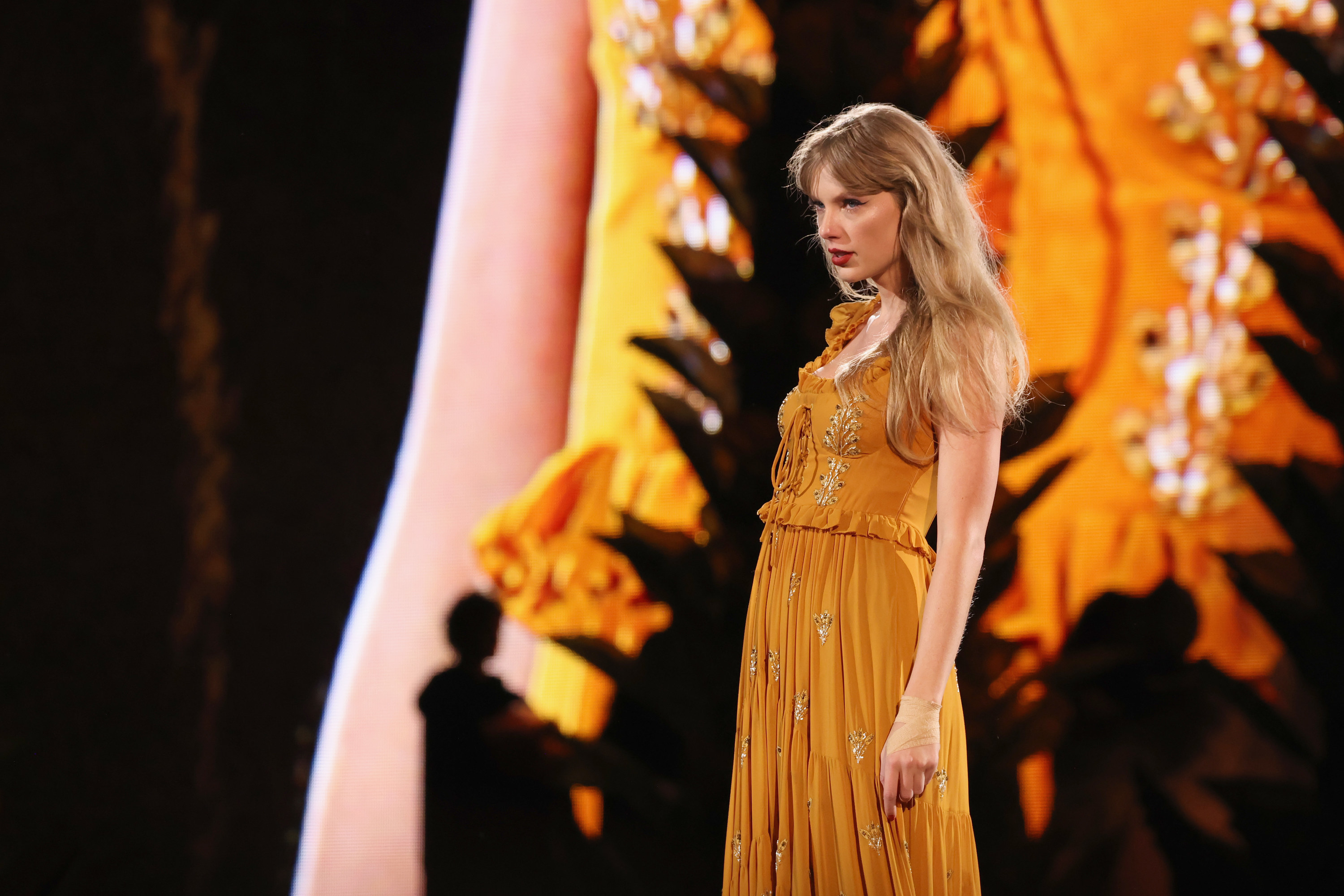 Taylor Swift wearing a golden floral dress