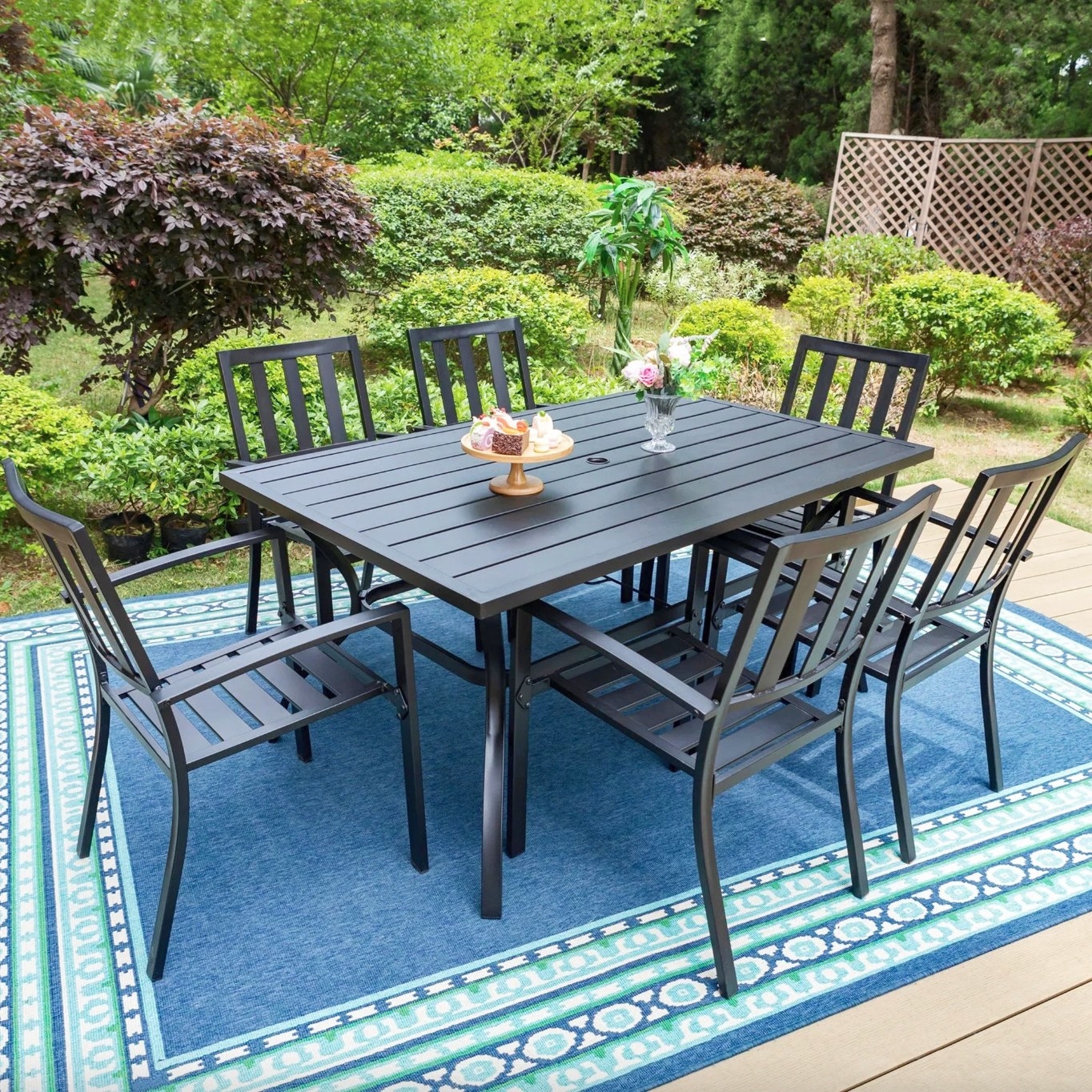 the black steel table and six chairs in a decorated patio space