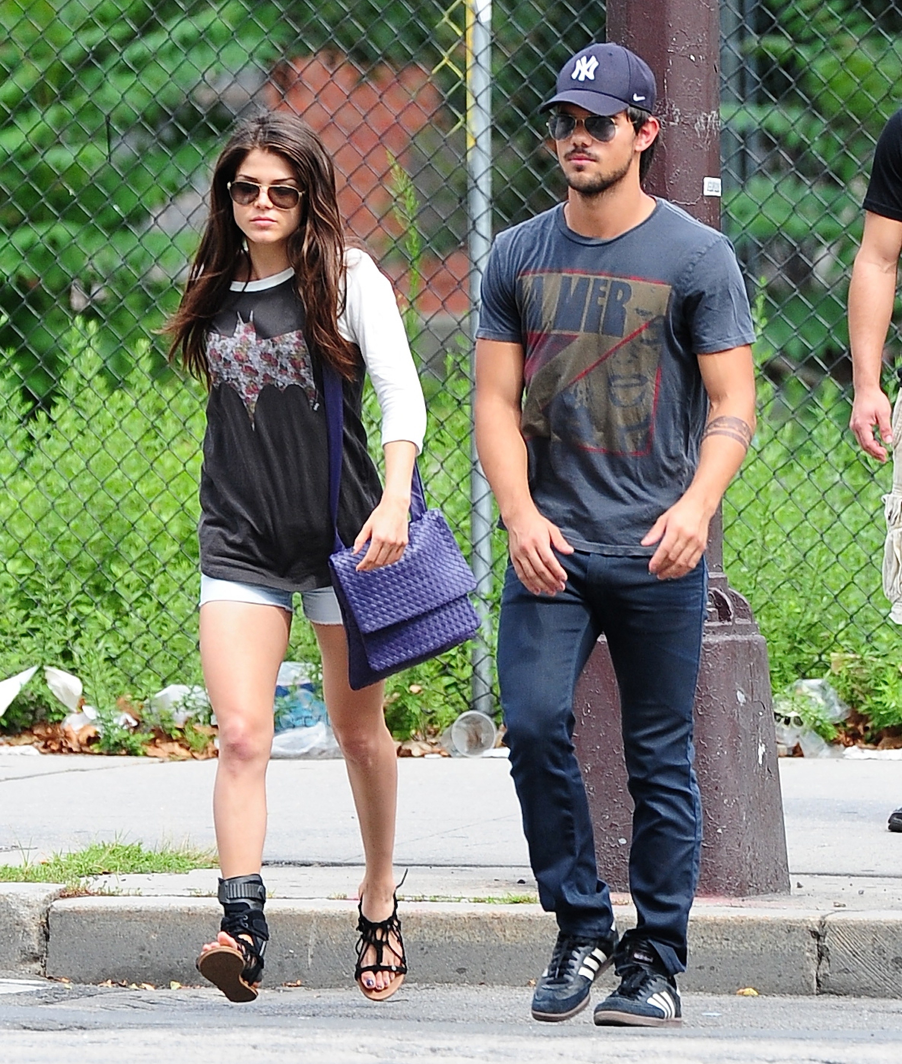 Taylor taking a walk with a companion while wearing sunglasses and a baseball cap