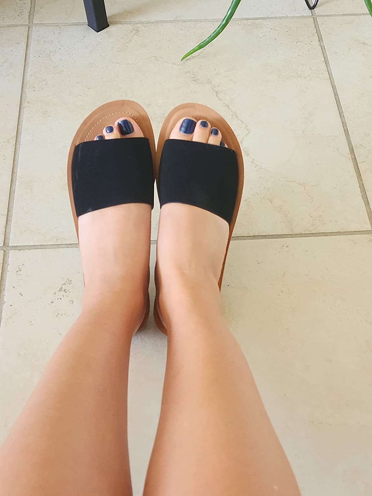 Reviewer wearing black slide sandals with brown sole