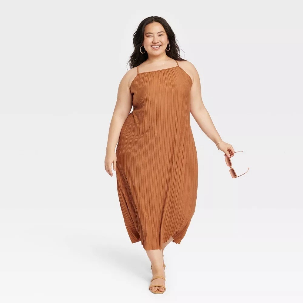 A model in the brown plisse dress
