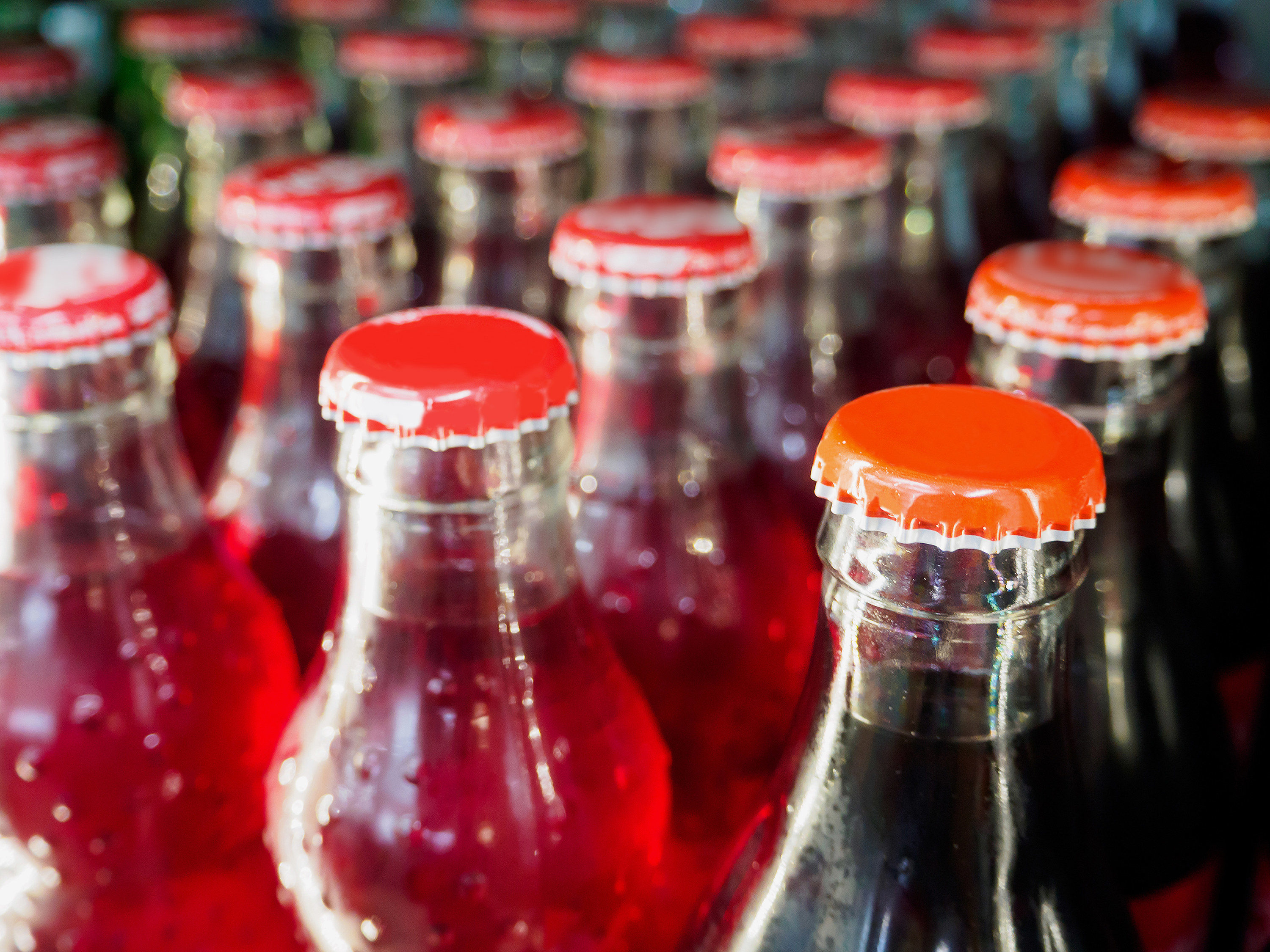 Rows of glass bottles filled with soda are pictured