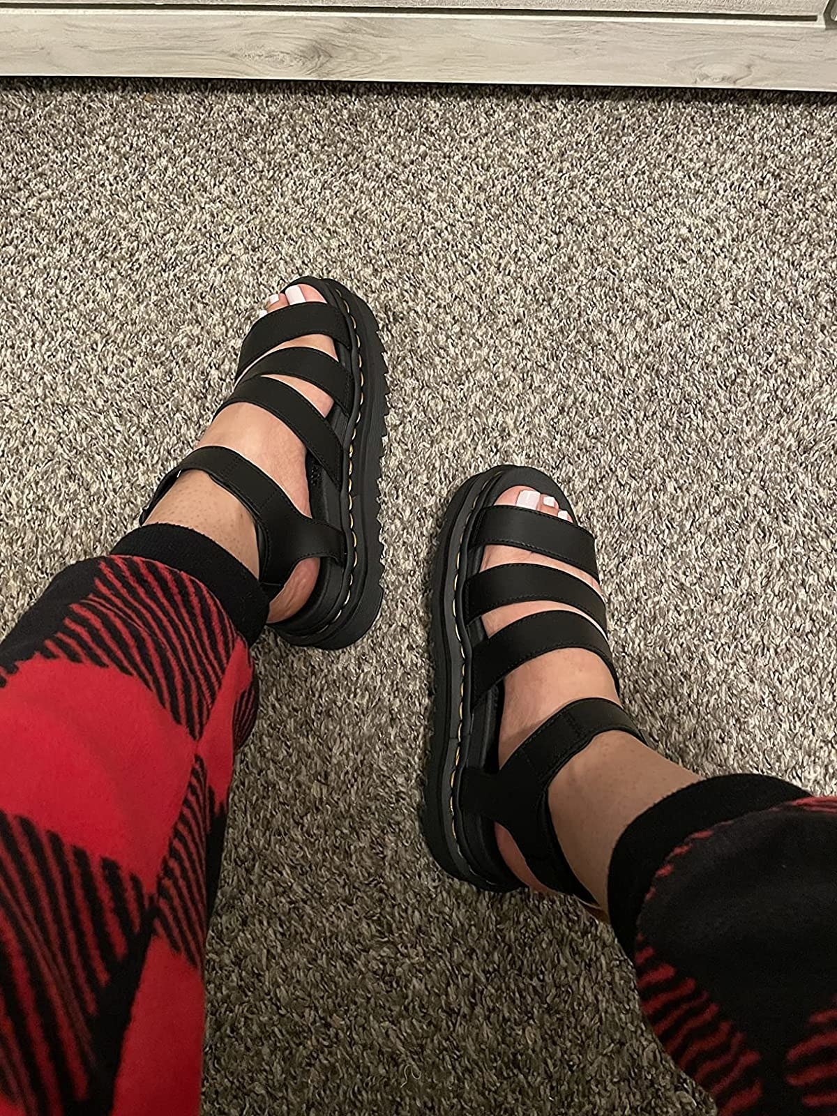 Reviewers wearing black strappy Doc Marten platform sandals